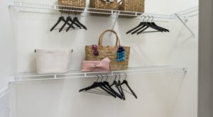baskets and hangers on a while shelf in a closet